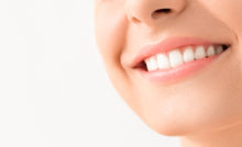 Beautiful smile young woman. White teeth on the master plan. Free space and background to use.
