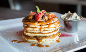 gingerbread pancakes topped with strawberries and syrup